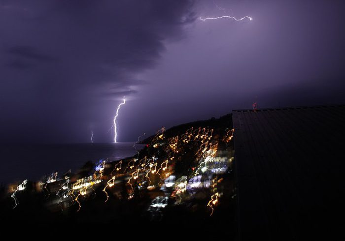 Lightning strike above a seashore city